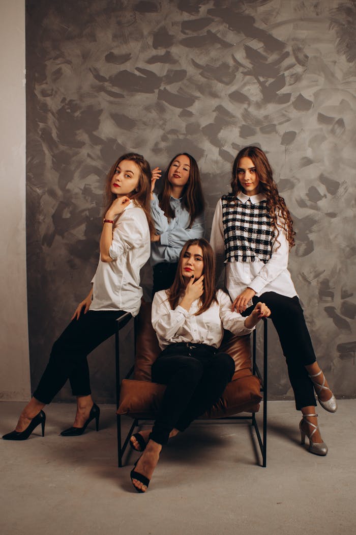 Four fashionable young women posing in a sophisticated indoor setting.